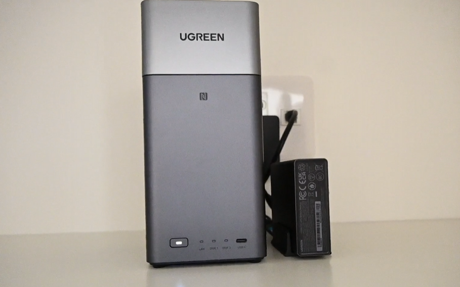 [画像：本体を斜め前から撮影。シルバー/ホワイト系の筐体がデスクの木目と馴染んでいる様子]