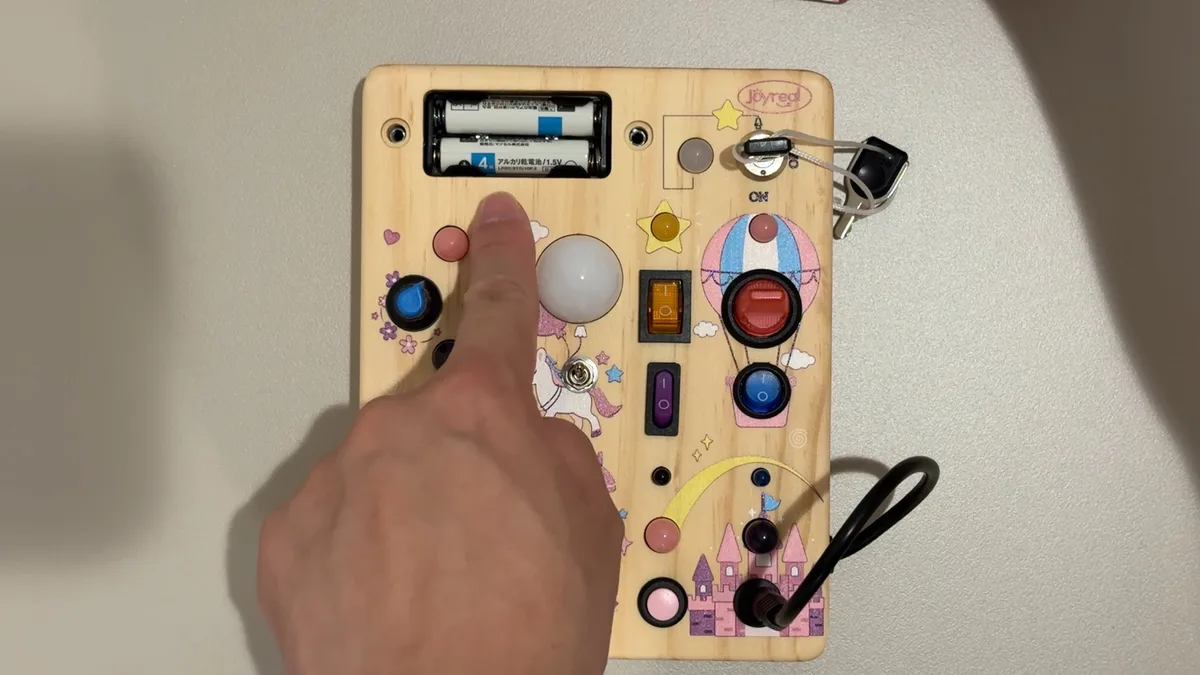 指でスイッチを押して遊ぶJoyrealビジーボードの使用シーン