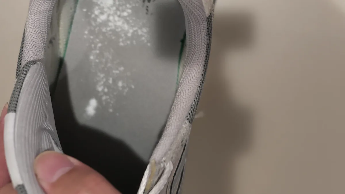 スニーカーの中にYohakuのパウダーを振りかける様子